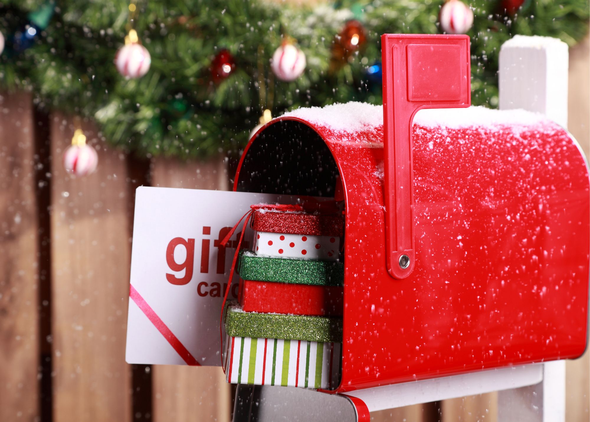 A holiday direct mail marketing campaign sitting in a snow covered mailbox during Holiday Season