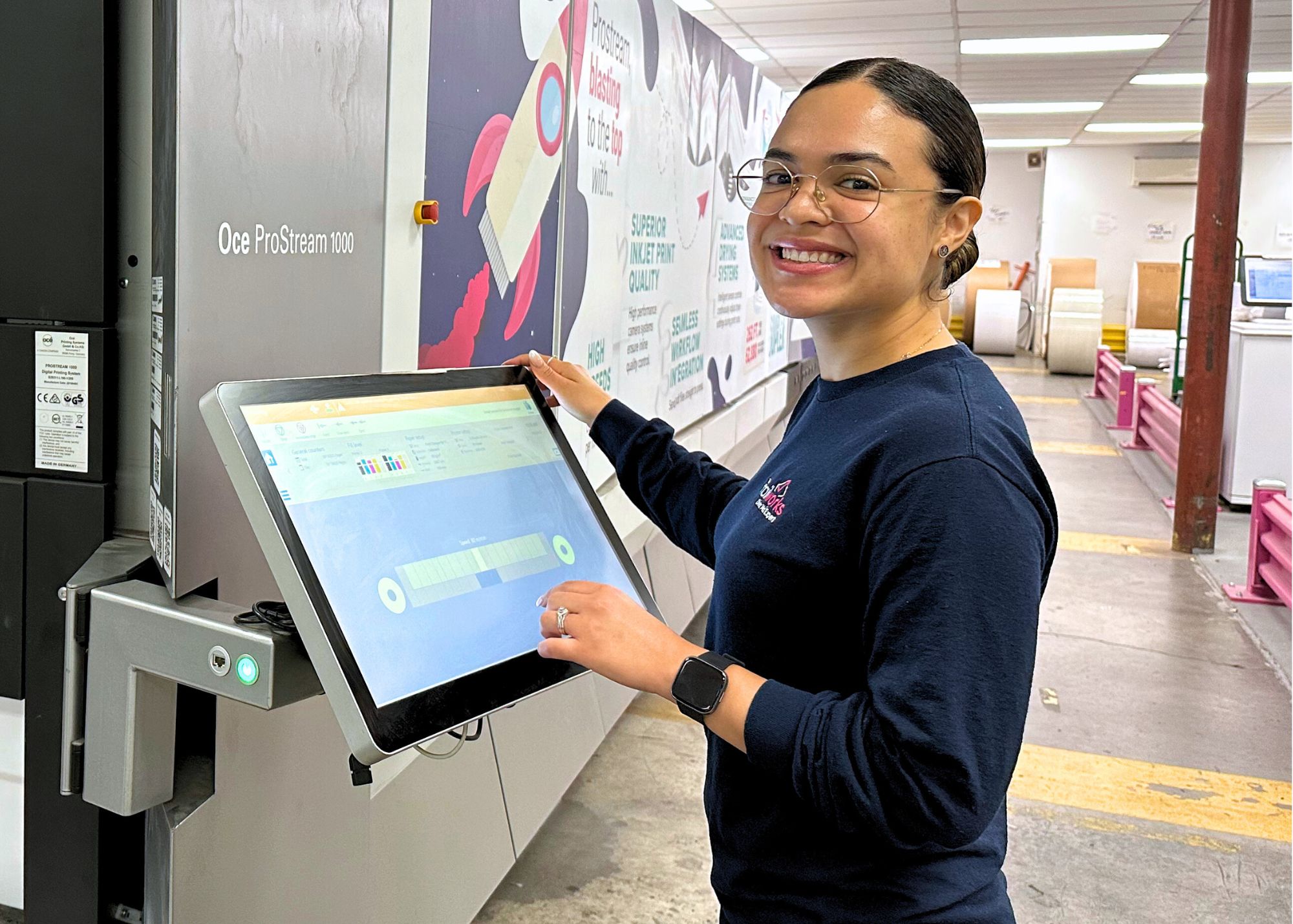 Woman standing in front of an industrial printer