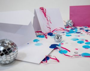 a still life photo of paper products with confetti and small disco balls